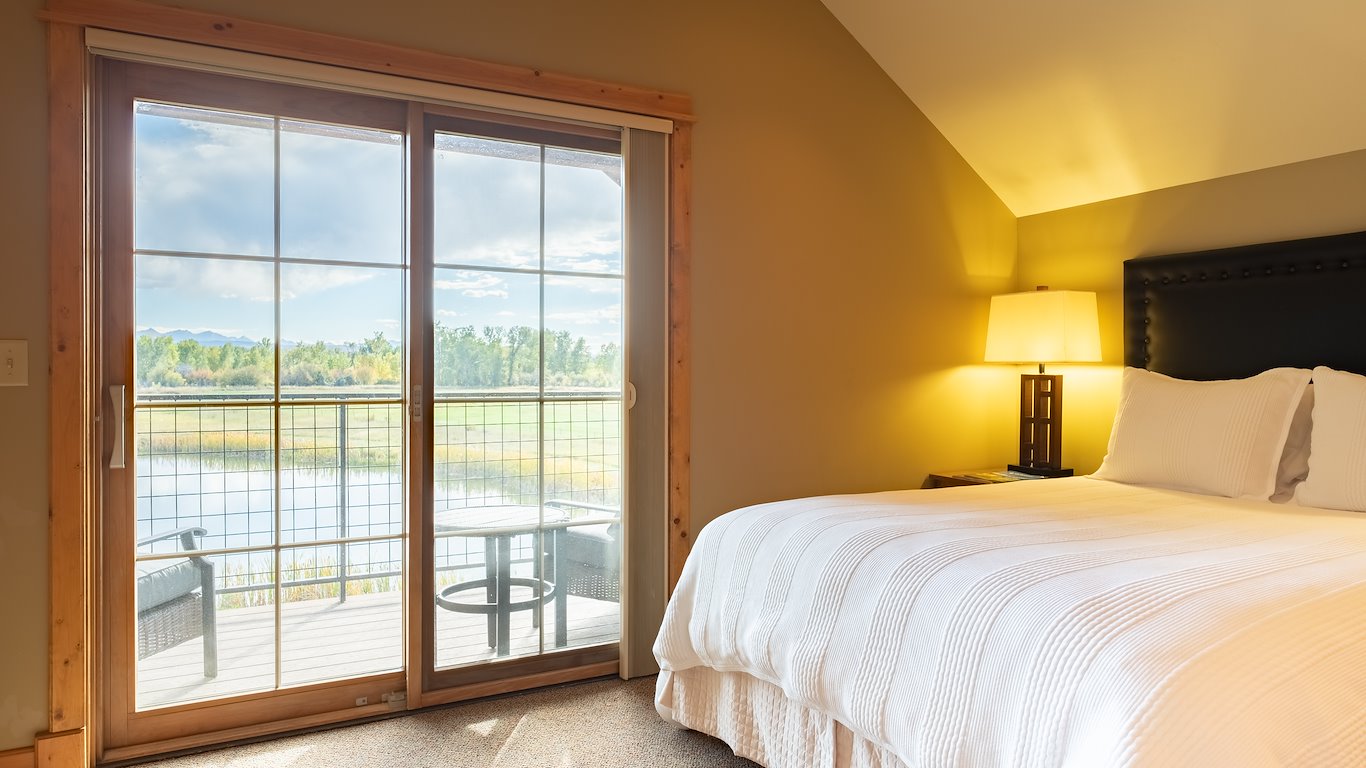 Cozy bedroom with lake view through window.