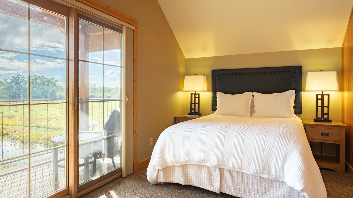 Cozy bedroom with patio view and warm lighting.