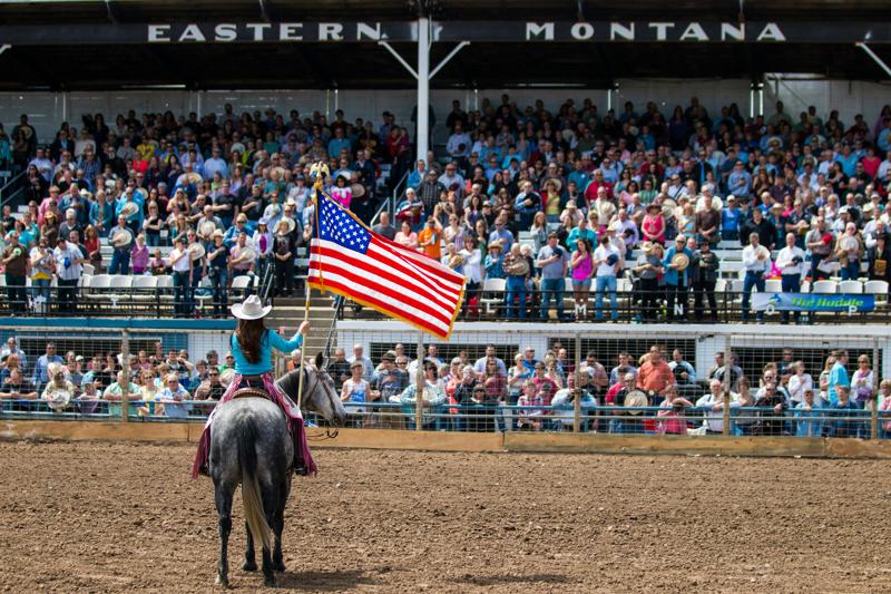 Rodeo rider with American flag at Montana event.