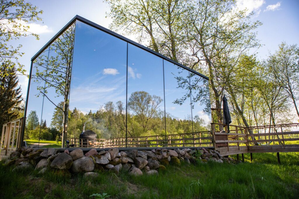 Modern glass cabin surrounded by lush forest