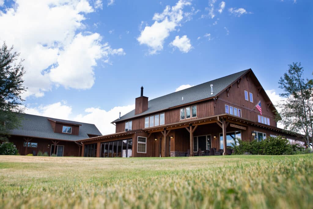 Rustic lodge with American flag and blue sky.