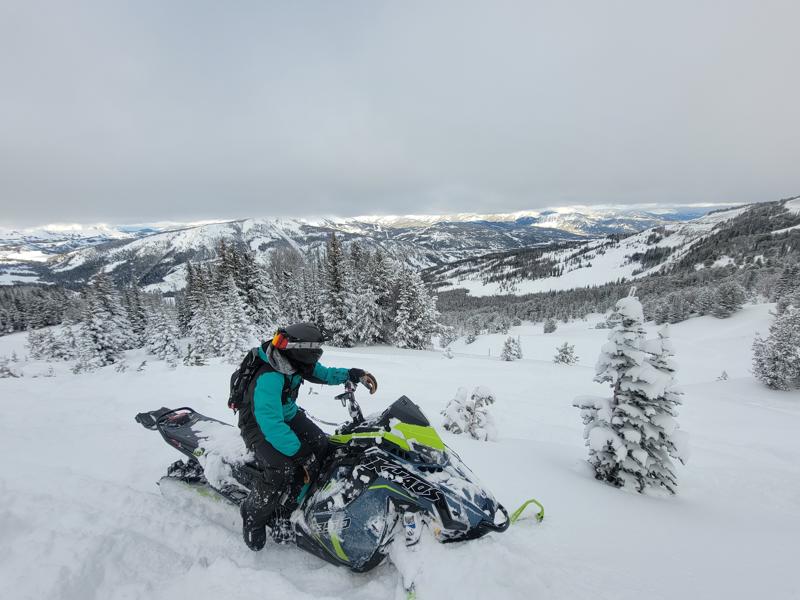 Person on snowmobile in snowy mountain landscape