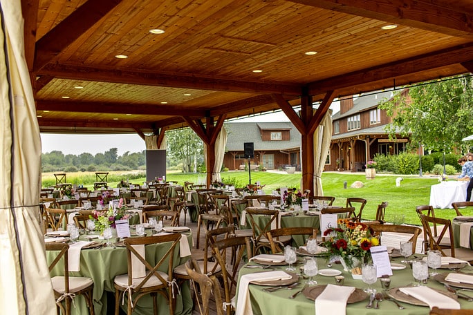 Outdoor event setup with tables and greenery.