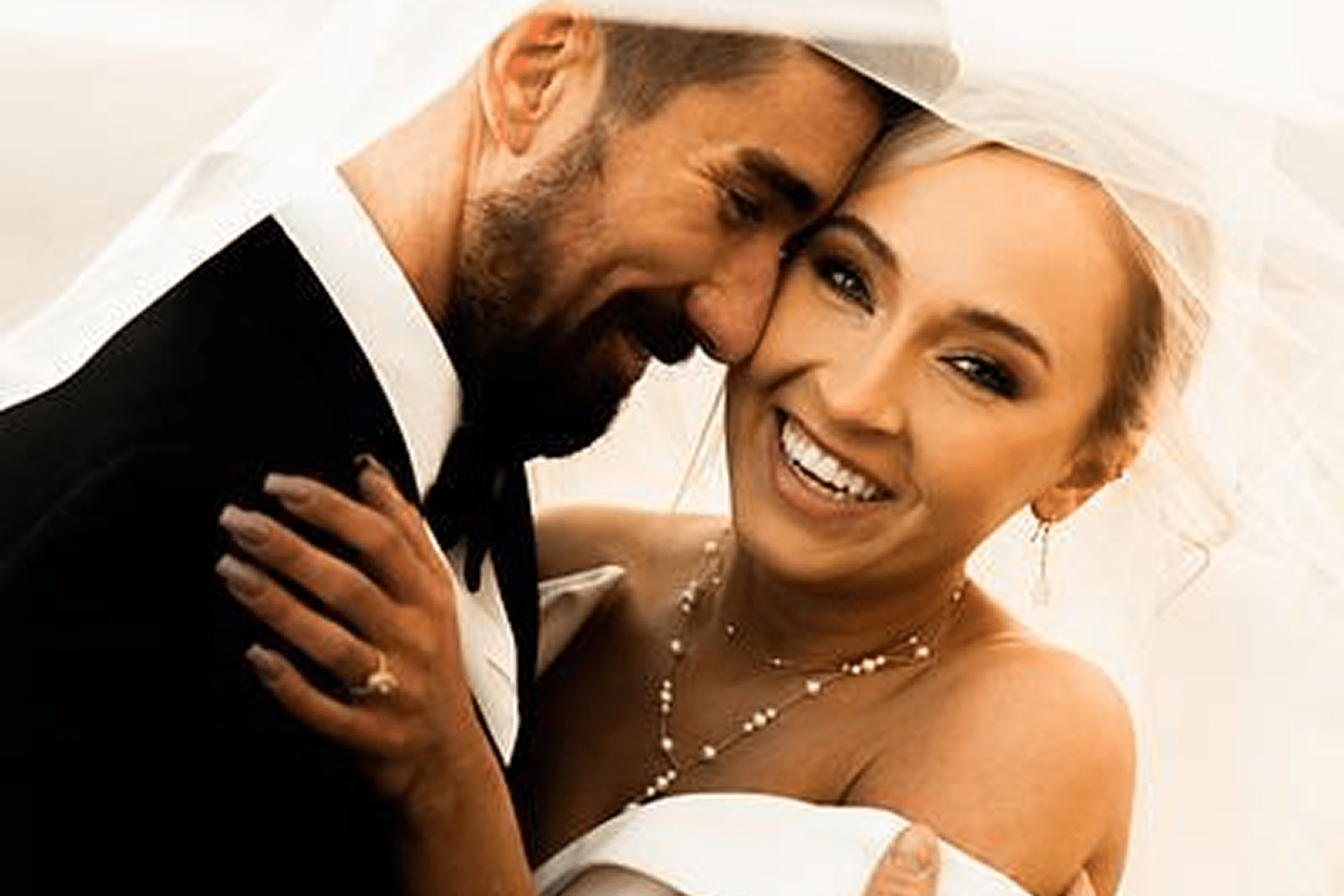 Smiling couple embracing on wedding day.