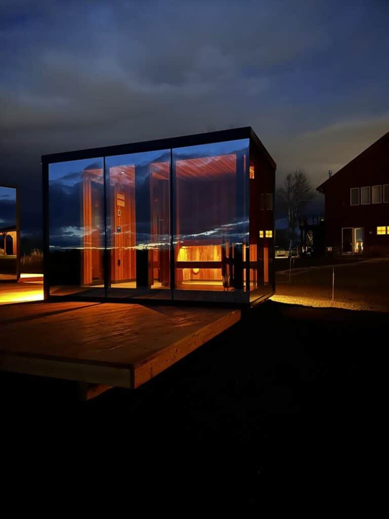 Modern glass cabin glowing warmly at night